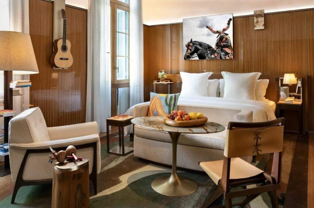 Aconchego e sofisticação na suíte do Rosewood São Paulo, que mistura madeiras e mármores nacionais; na parede, um dos violões assinados por Caetano Veloso e Gilberto Gil